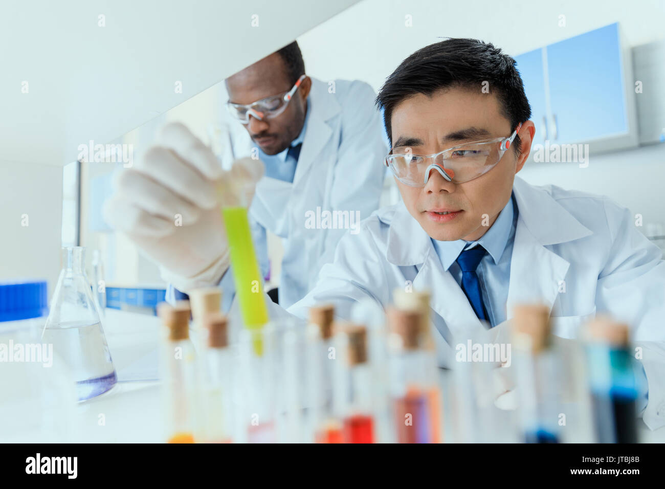 Professionelle Wissenschaftler in weißen Kitteln zusammen im chemischen Labor Stockfoto