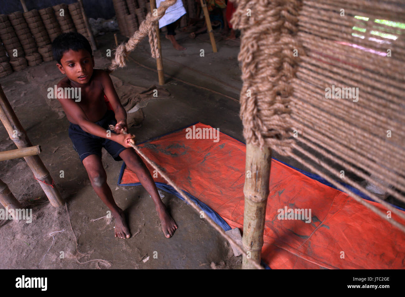 Ein Kind Arbeitskräfte, die in einem Seil verarbeitenden Fabrik in Keraniganj in Dhaka am 09 Juni, 2013. Stockfoto