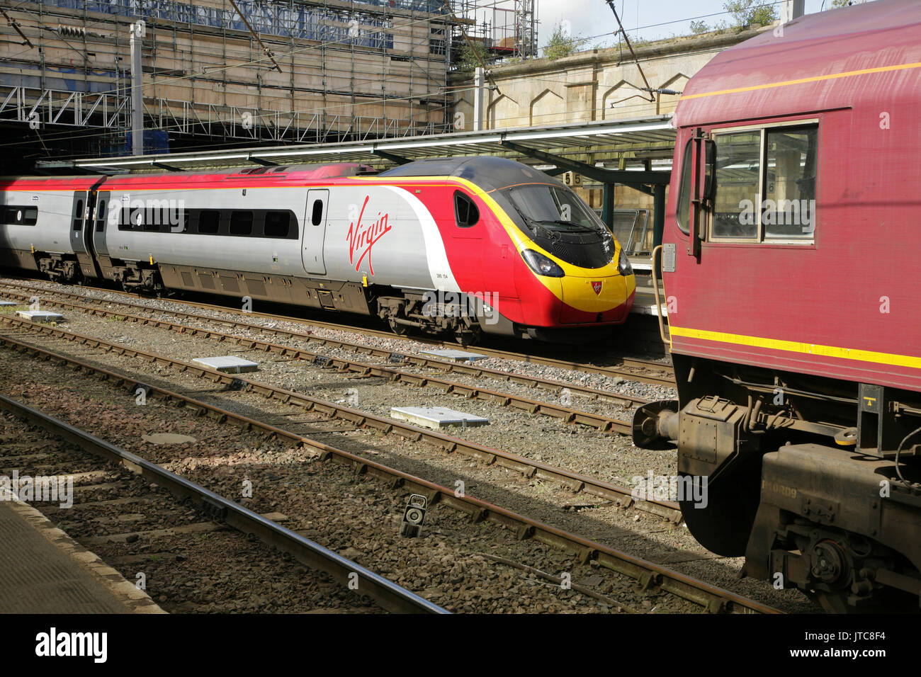Virgin Trains Class 390 Pendolino Hochgeschwindigkeitszug und EWS Class 66 Diesel Lokomotive in Carlisle Station. UK. Stockfoto