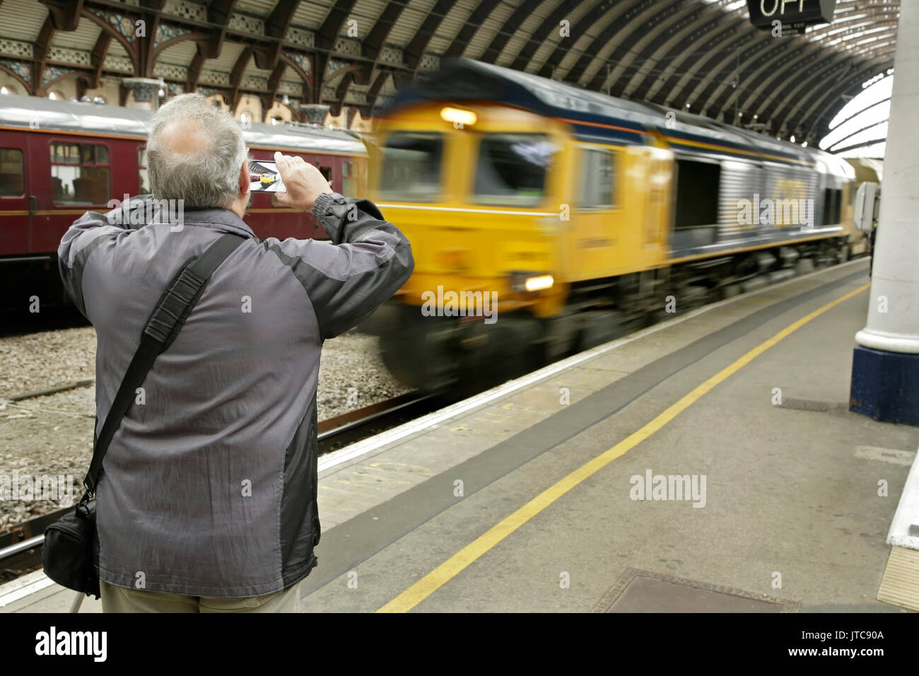 Rail Enthusiast fotografieren GBRF Class 66 Lokomotive durch York Station, Großbritannien Stockfoto