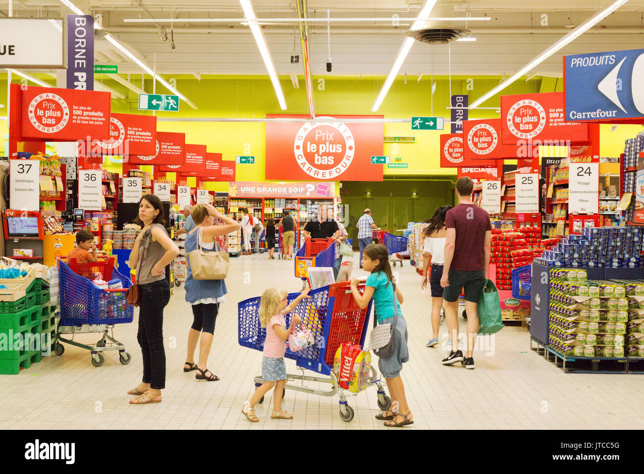 Kinder Einkaufen in einem französischen Supermarkt - Innenraum von Carrefour Supermarkt, Quimper, Bretagne Frankreich Stockfoto