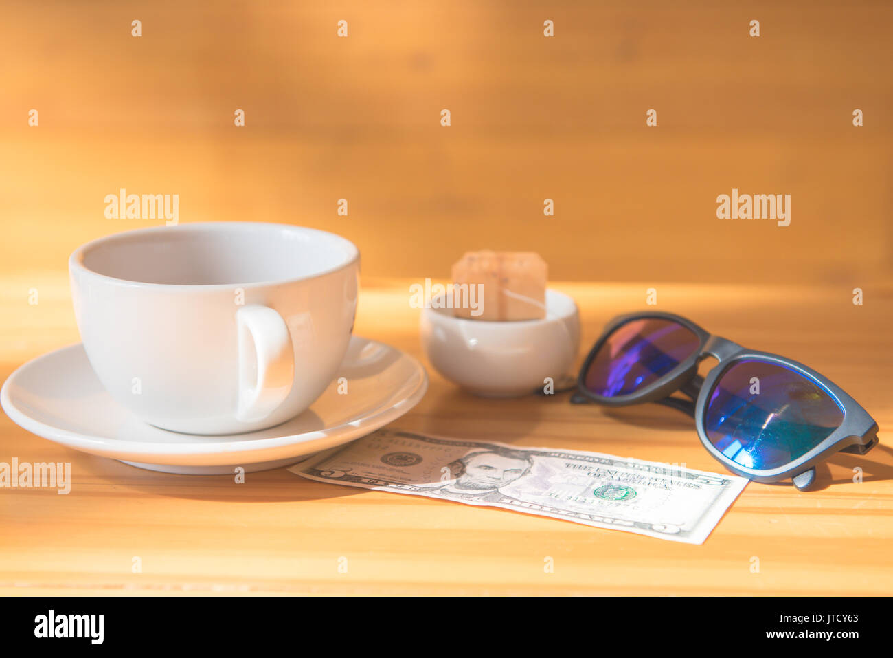 Geld Tipp stellen Dollar oder Euro für Reisen und Tee Tasse in der Nähe von auf dem hölzernen Tisch Stockfoto