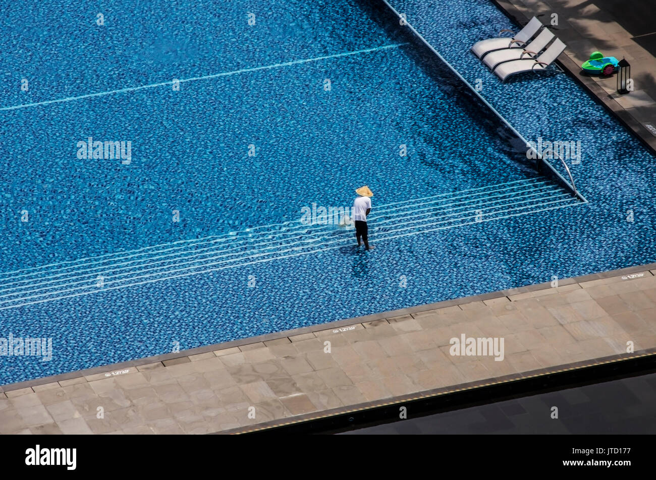 Mann Reinigung Outdoor Swimmingpool in einem tropischen Hotel Stockfoto