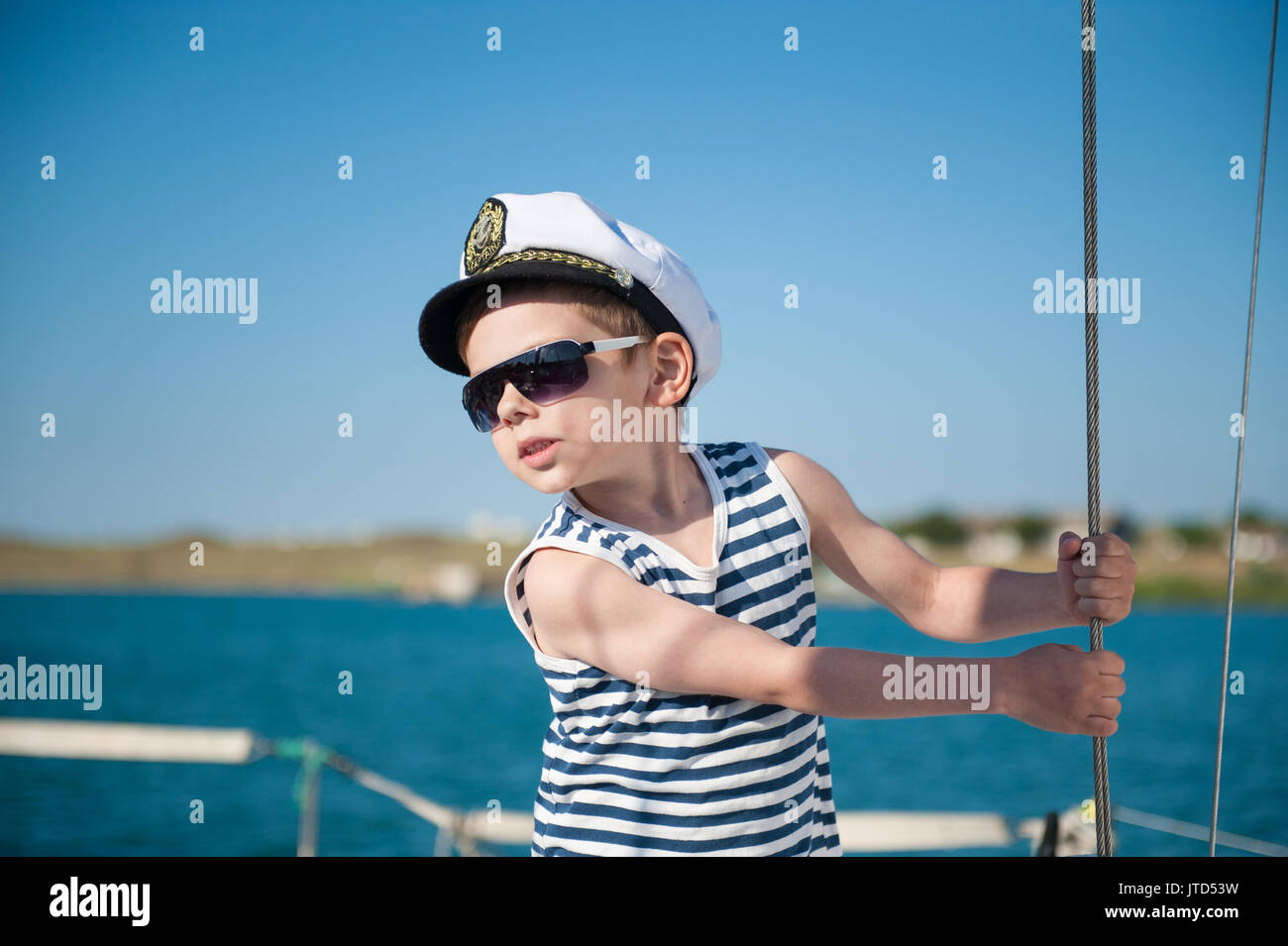 Süße kleine Kapitän an Bord meer Schiff Stockfoto