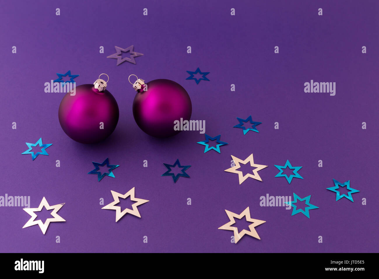 Schönen lila Weihnachtskugeln mit satin Wirkung und metallic silber und blaue Sterne auf lila Hintergrund. Stockfoto