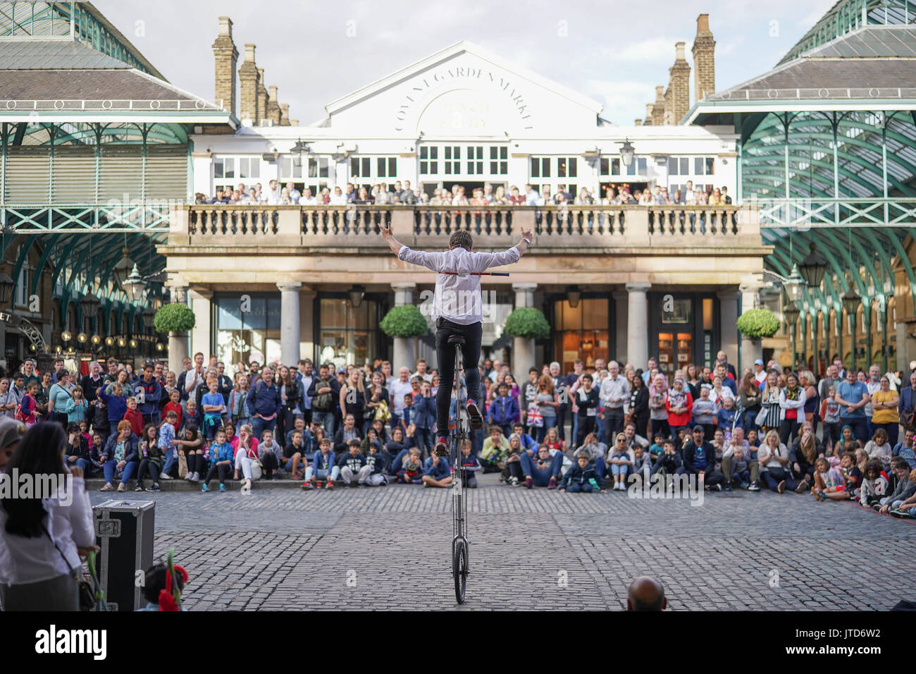 Ein entfesselungskünstler Einradfahrer durchführen für Massen in Covent Garden in London. Aus einer Reihe von Bildern von Straßenkünstlern in London, UK. Foto Datum: Stockfoto
