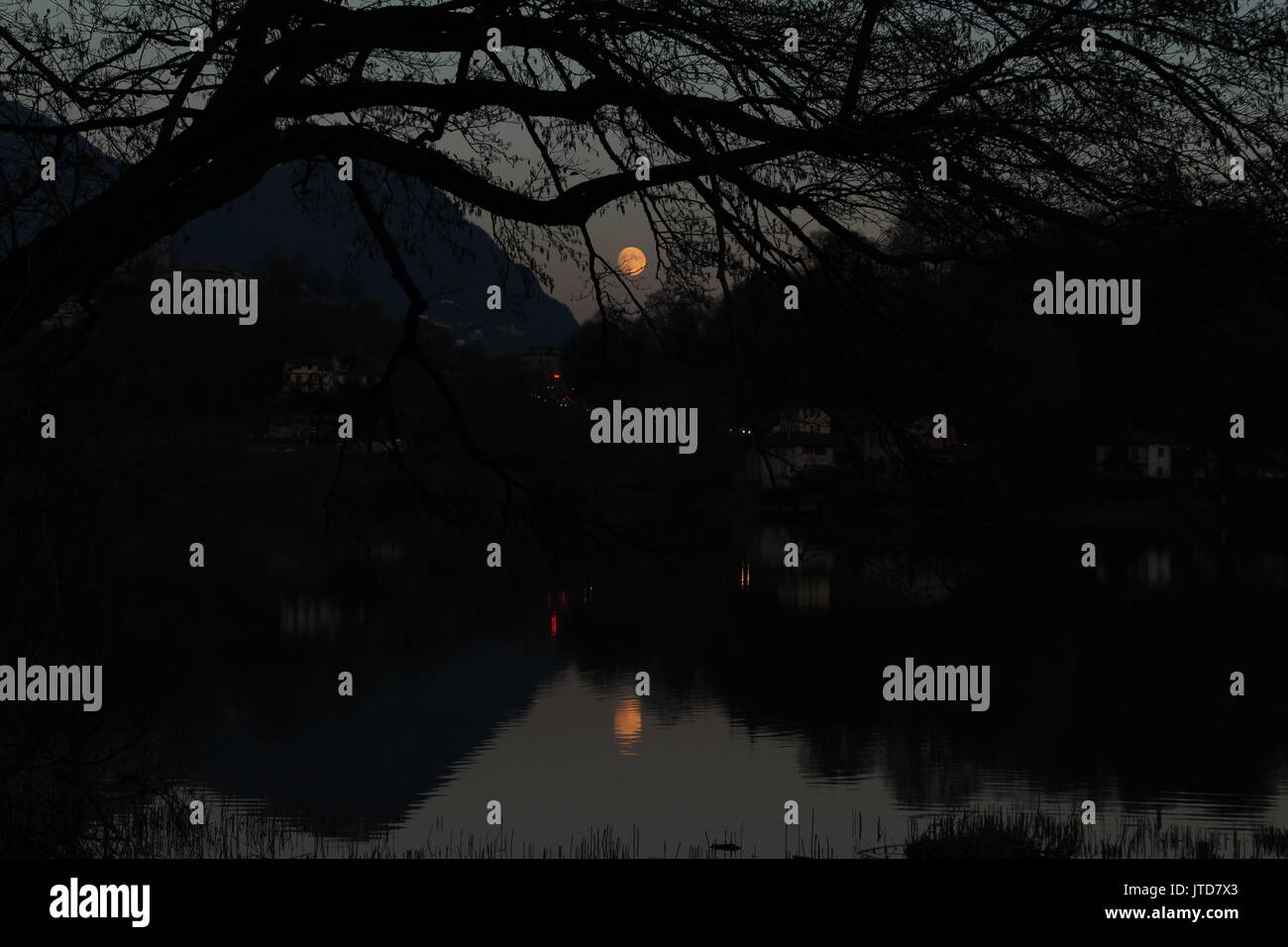 Die Spiegelung des Mondes und die Alpen auf einem See in der Schweiz, in Europa. Stockfoto
