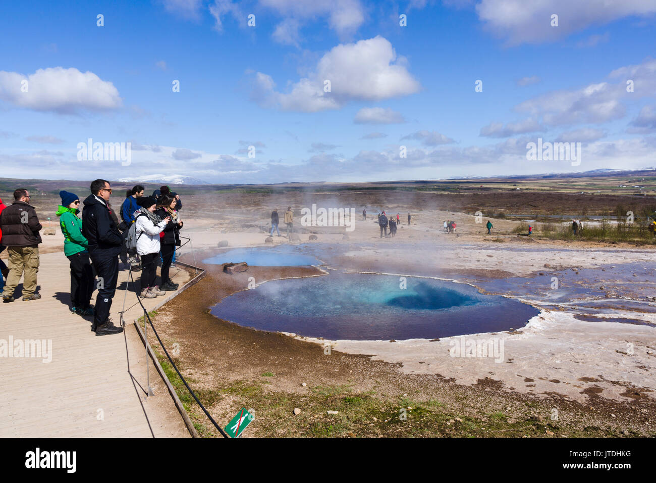 Touristen das Anzeigen einer Schlamm Topf im Geysir geothermische Gebiet, Island Stockfoto