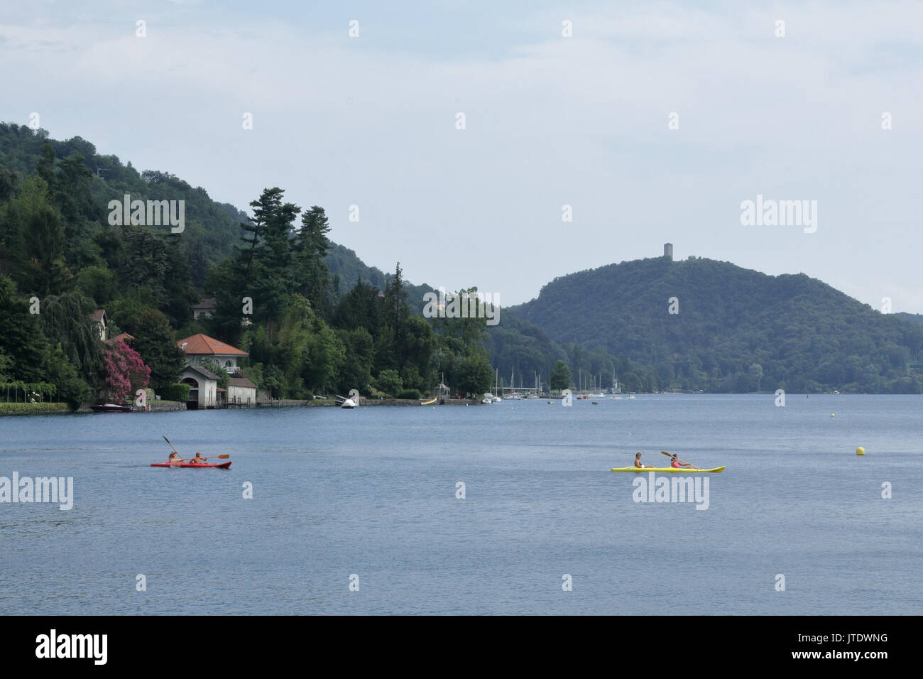 Ein Haus mit Bäumen neben dem Orta See ufer in Novara Provinz, Norditalien, mit zwei pirogen Stockfoto