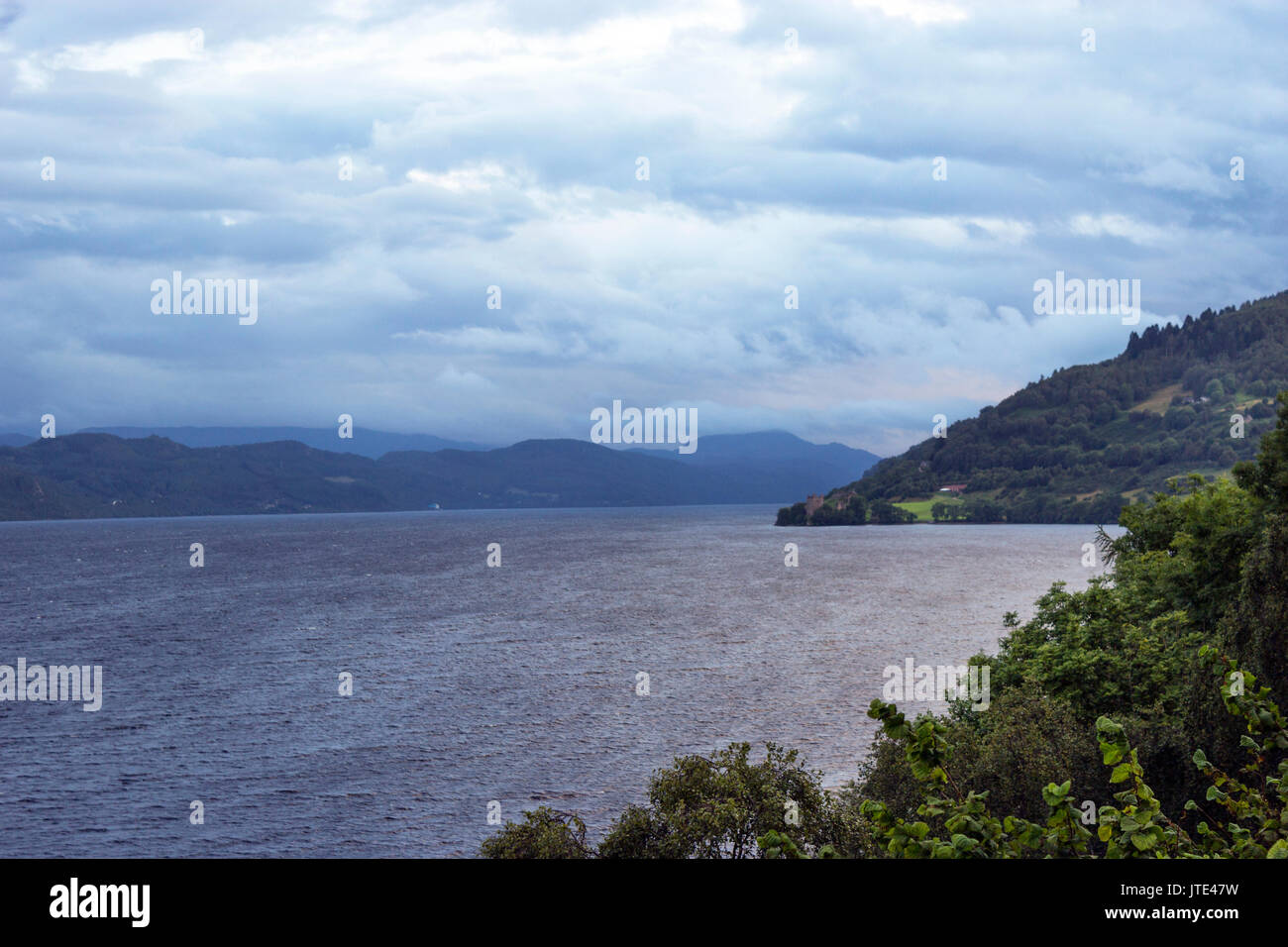 Schottland, Highlands, Schottische Landschaft, Klares Wasser, Meer, Berggipfel, Blaues Wasser, Bäume, Landschaft, Natur, Loch Ness, Dramatische Skyline Stockfoto