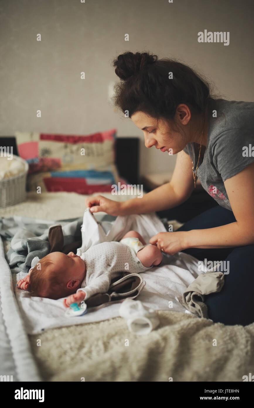 Junge Mutter ändern Baby Kleidung Stockfotografie - Alamy
