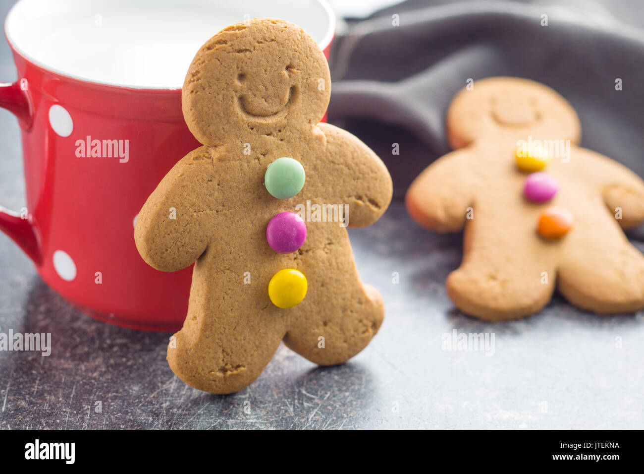 Gingerbread Man lehnte sich gegen eine Tasse auf alten Küchentisch. Weihnachten Lebkuchen. Stockfoto