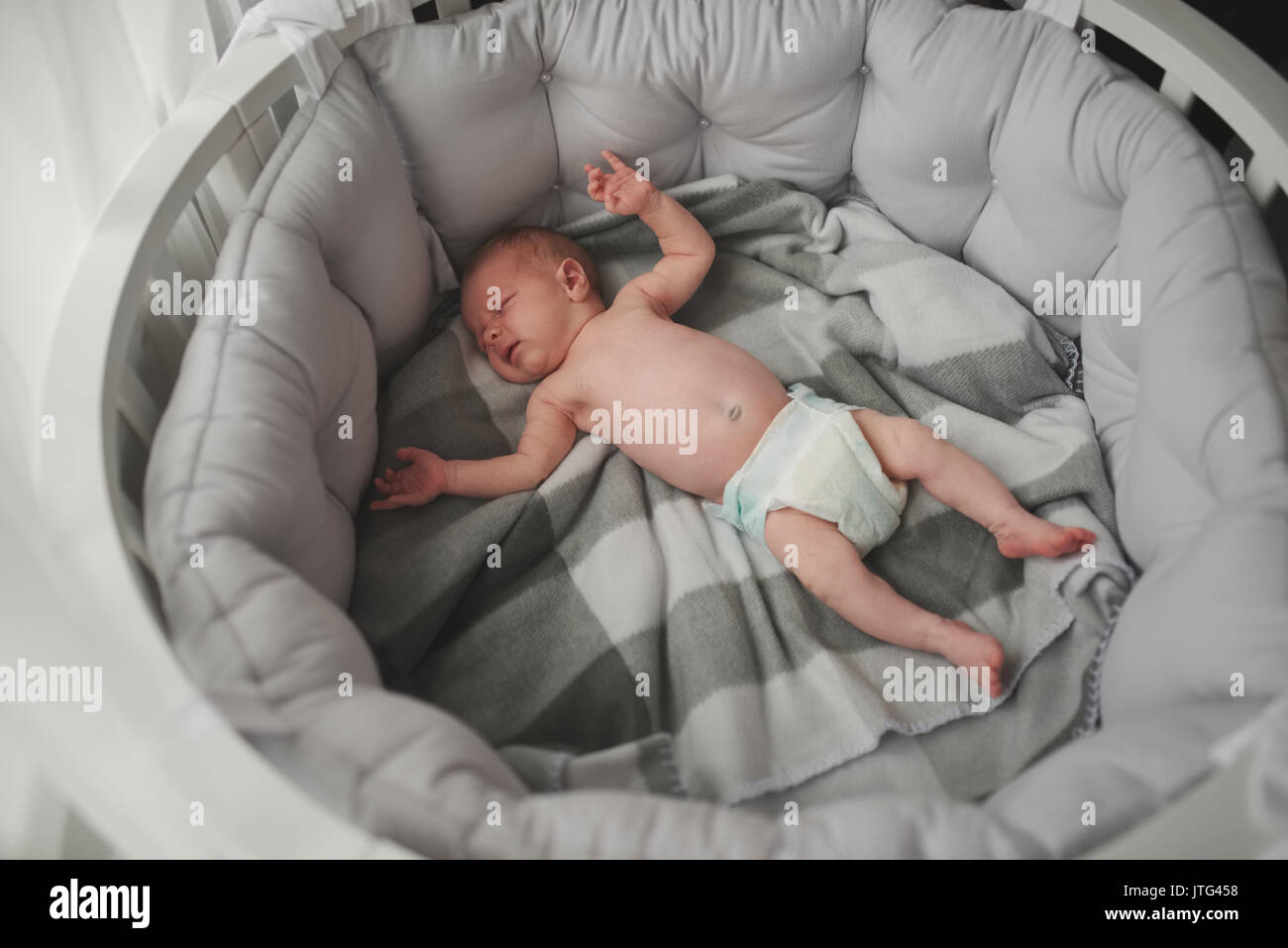 Süßes Neugeborenes im großen Bett liegen Stockfoto