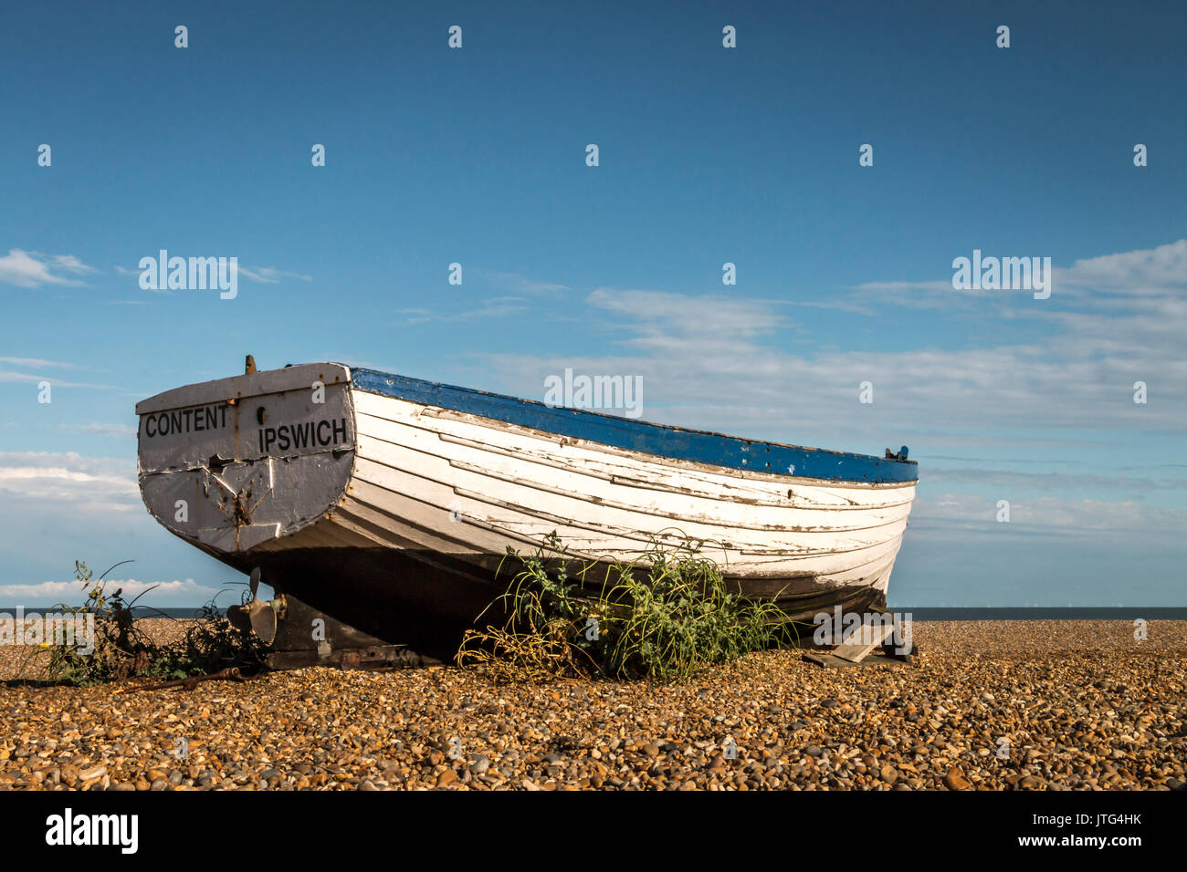 Historische hölzerne Fischerboote sitzen im Sommer Sonne auf der Kiesstrand in Aldeburgh an der Küste von Suffolk in Großbritannien. Stockfoto