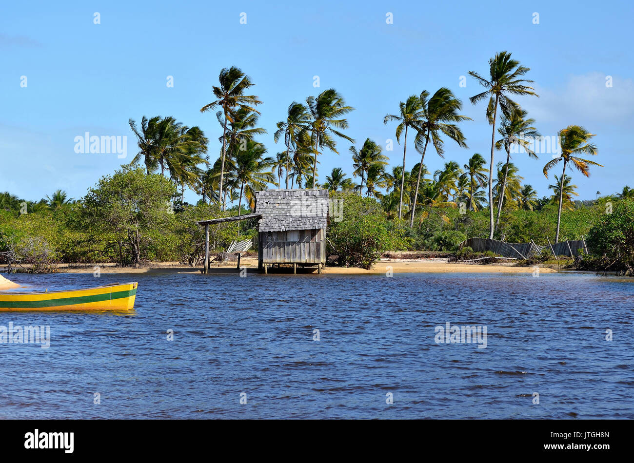 Kleines Holzhaus auf einem brasilianischen Küste Strand durch den kleinen Fluss Bank in Canoa Quebrada in der Stadt Porto Seguro, Bahia, Brasilien umgeben. Stockfoto