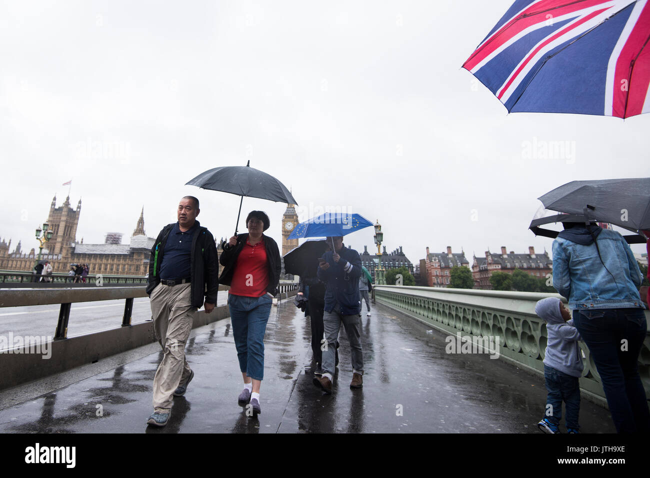 London, Großbritannien. 9. August 2017. Touristen und Pendler zu Fuß über die Westminster Bridge in London, UK als schwerer Regen die Stadt trifft. Credit: Ben Furst/Alamy Leben Nachrichten. Stockfoto