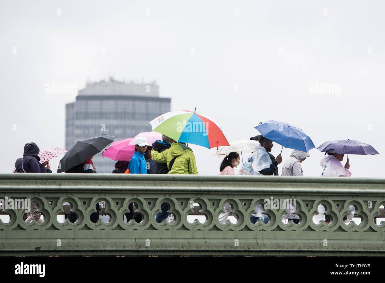 London, Großbritannien. 9. August 2017. Touristen und Pendler zu Fuß über die Westminster Bridge in London, UK als schwerer Regen die Stadt trifft. Credit: Ben Furst/Alamy Leben Nachrichten. Stockfoto