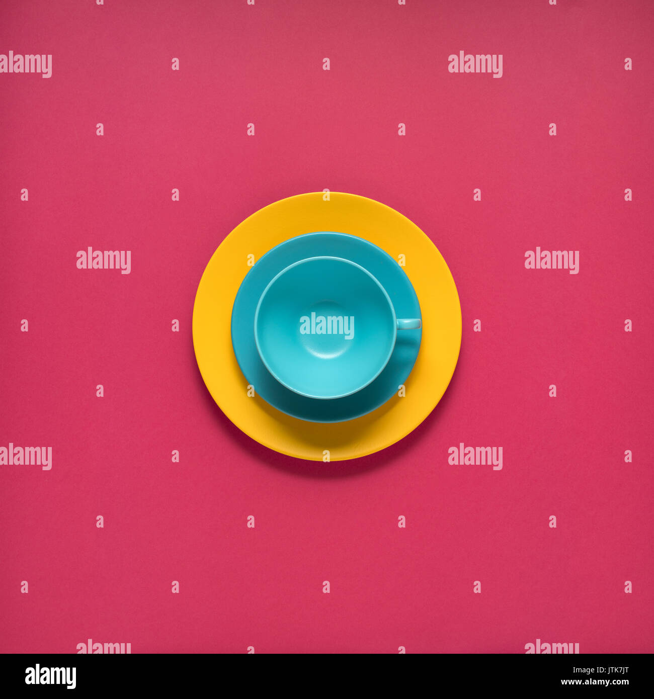 Kreatives Konzept Foto von Küchenutensilien, bemalte Teller mit Essen auf es auf rosa Hintergrund. Stockfoto