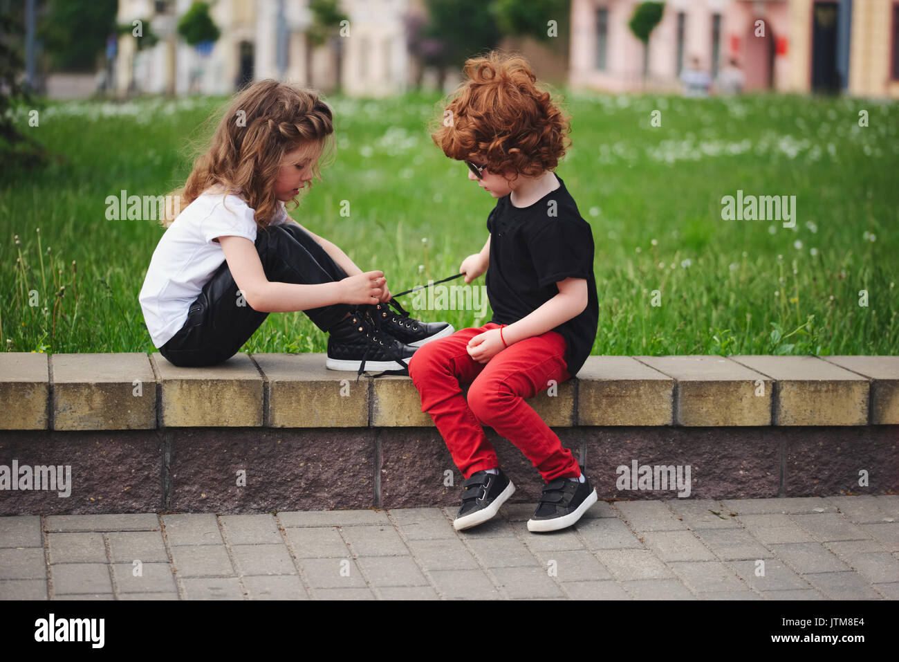 Junge Mädchen hilft, Schnürsenkel binden Stockfoto