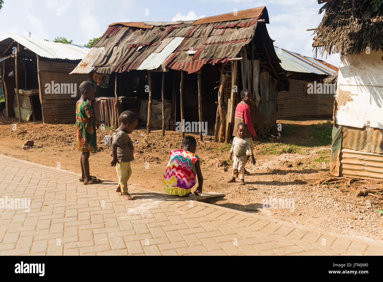Wellblech und Holz- shack Gebäude mit kleinen Kindern spielen im Freien, Kenia Stockfoto