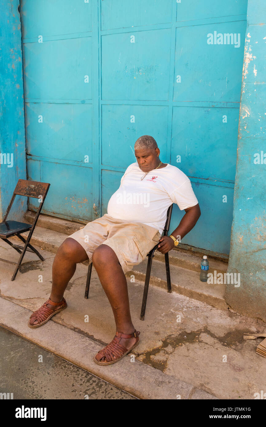 Siesta, Kubanische Mann schlafend auf einem Stuhl in einer Straße in der Altstadt von Havanna, Kuba Stockfoto