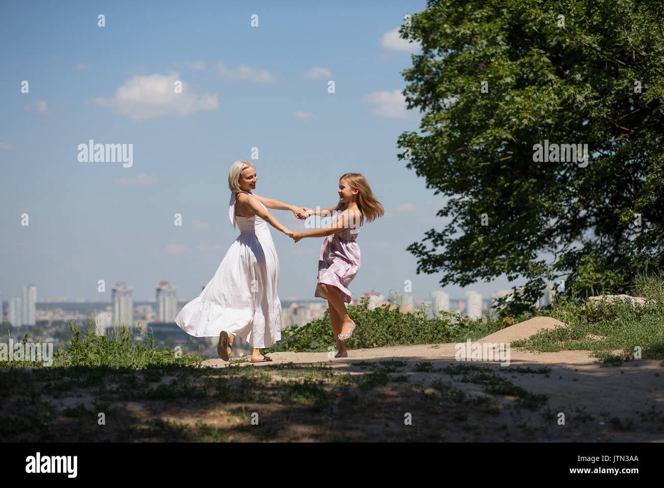 Mama und Tochter tanzen im City Park. Stockfoto