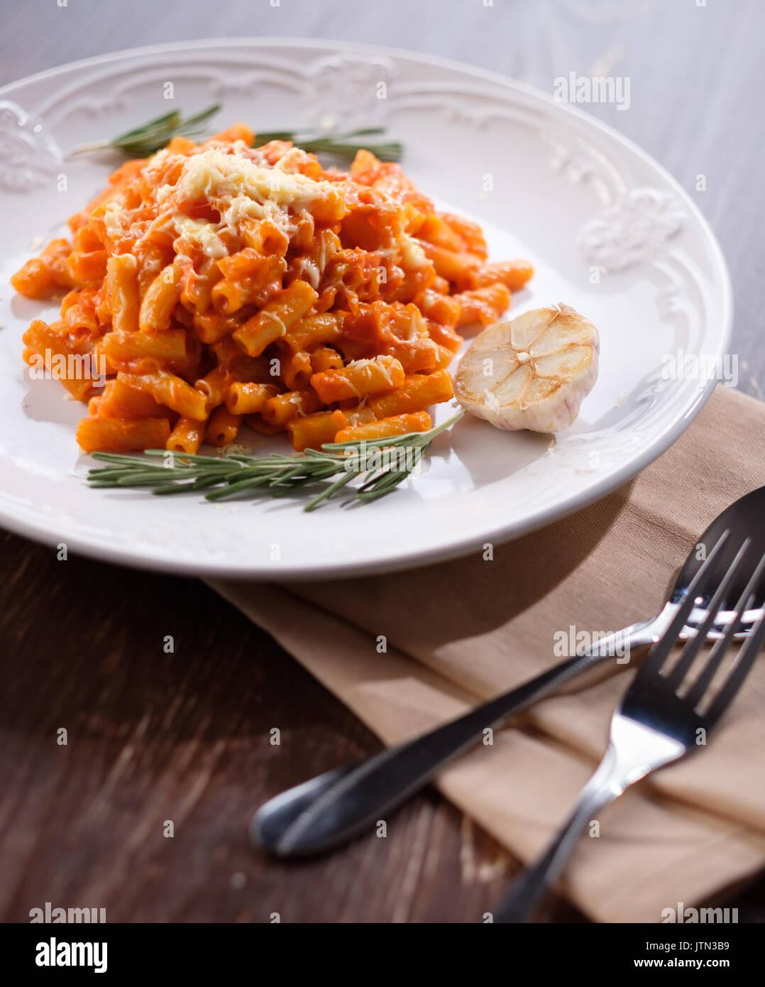 Italienische Pasta mit Tomaten, Käse und Knoblauch. close-up auf einem Teller mit geschmolzenem Käse. Stockfoto