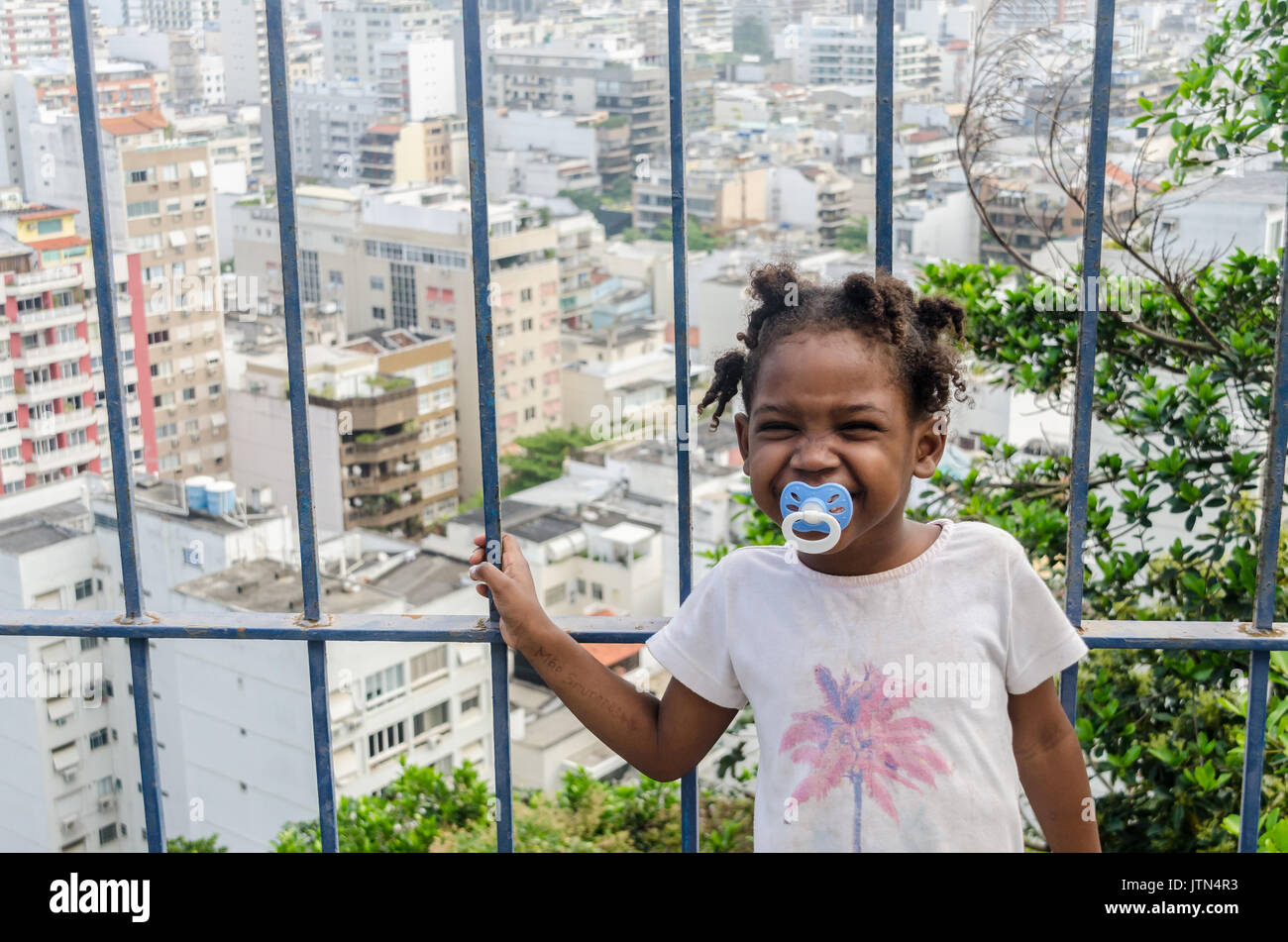 Ein Mädchen (4-6) lächelt mit Ipanema, Rio de Janeiro Hintergrund. Eine Nachricht geschrieben am Arm eines Mädchens, die übersetzt "ich vermissen sie Mutter". An Cantagalo genommen Stockfoto