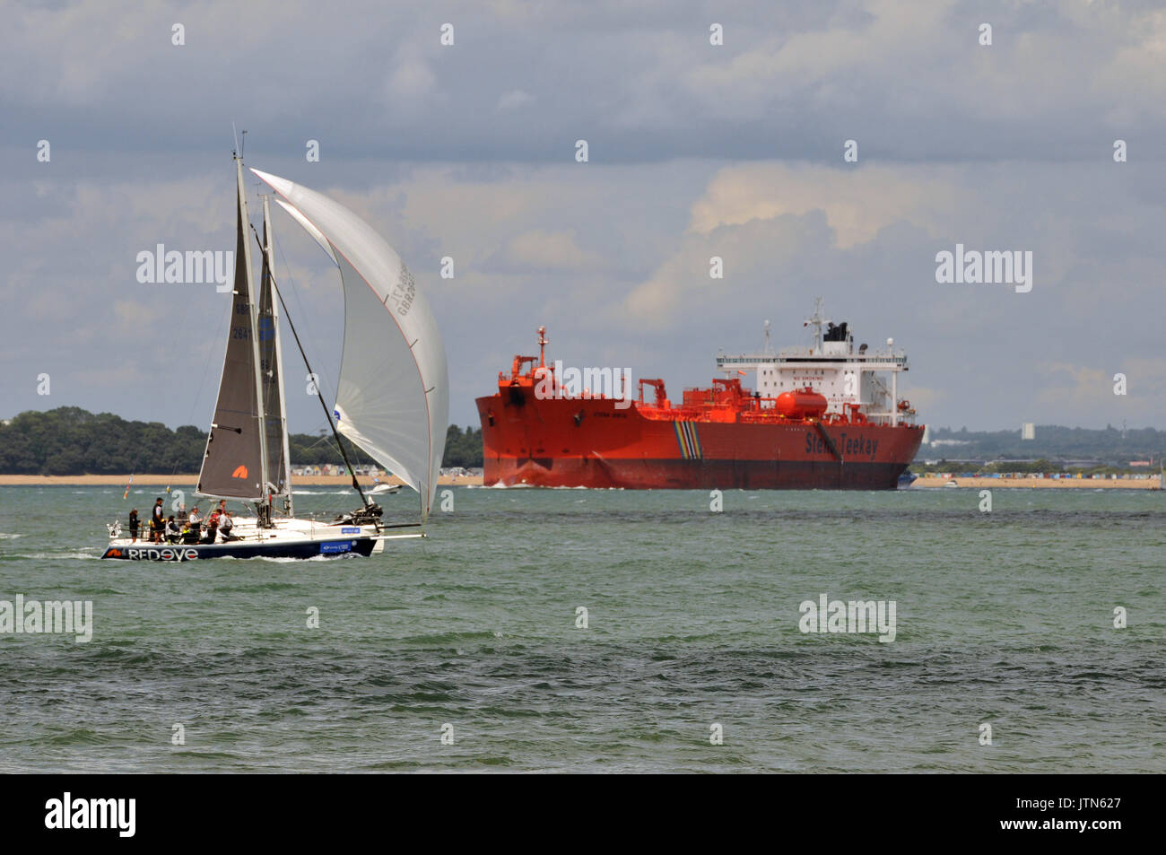 Eine große Öltanker und einer Yacht im Dorn Kanal in der Nähe von Southampton Solent Wasser. Stockfoto