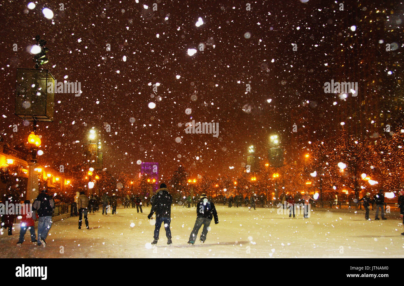 Leute genießen Eislaufen während der verschneiten Nacht in Chicago. Stockfoto