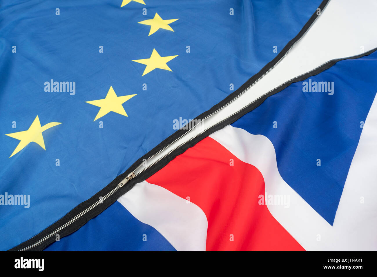 Entzippen / Abtrennen / Aufheben der EU-UK-Beziehung nach 40 Jahren - Brexit-Konzept - Union Jack und EU-Flaggen trennen sich. No-Deal-Brexit. Stockfoto
