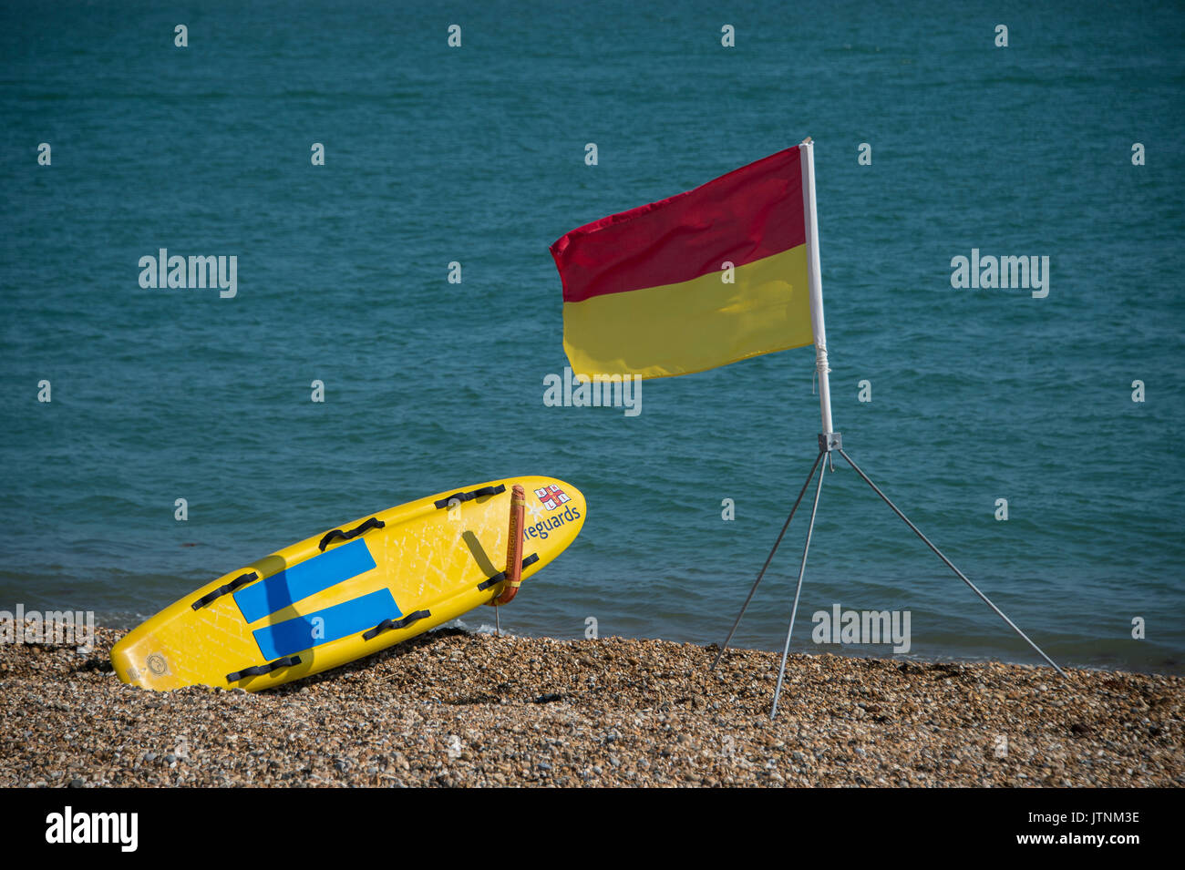 Southsea Strand mit roten und gelben sicheres Baden zone Flagge mit Rettungsschwimmern rescue Board. Stockfoto
