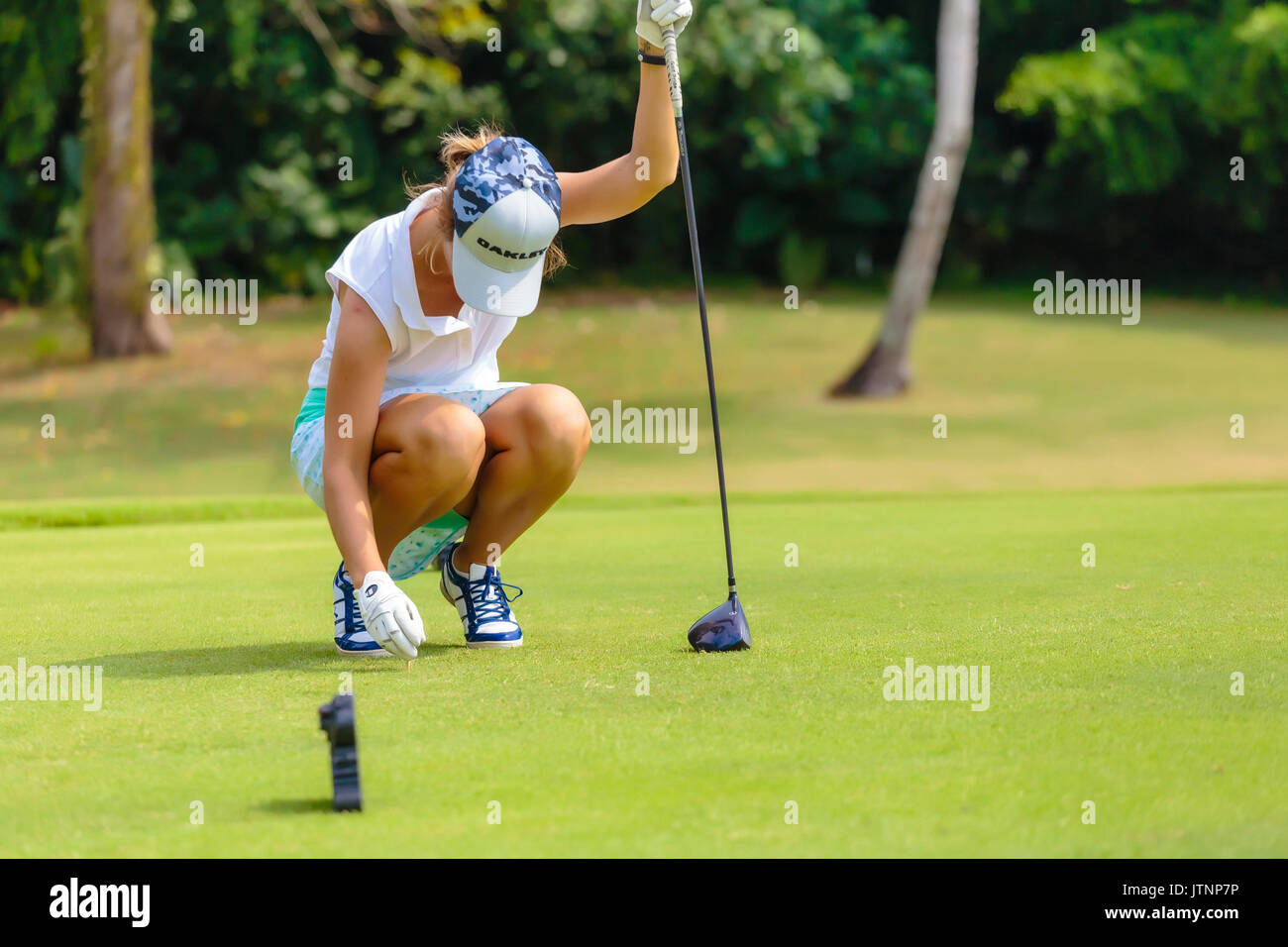 Junge Frau Inverkehrbringen Golfball auf T-Stück Stockfoto