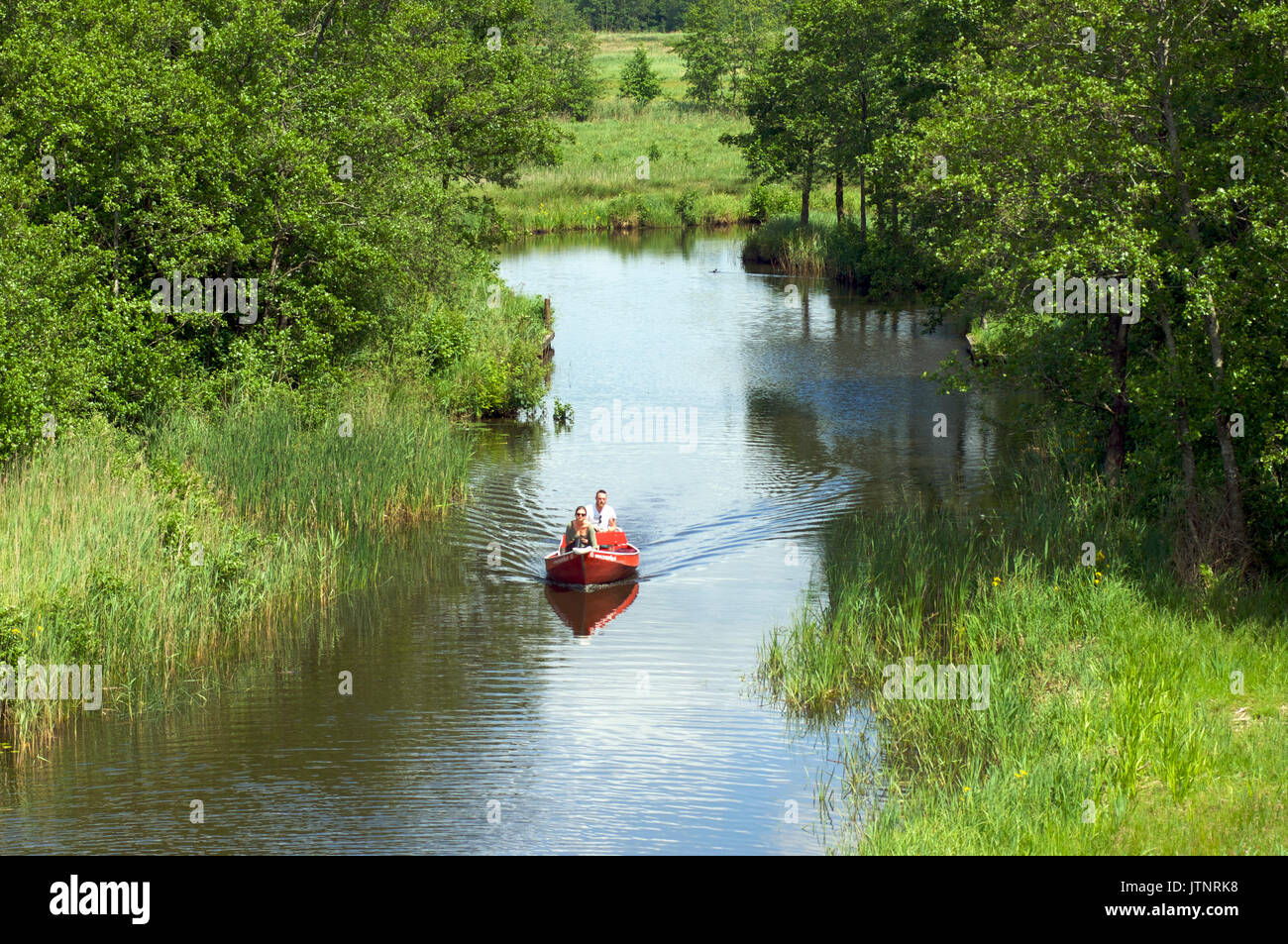 Paar in einem Motorboot genießt die Natur auf dem Wasser in der Nähe von Giethoorn Stockfoto