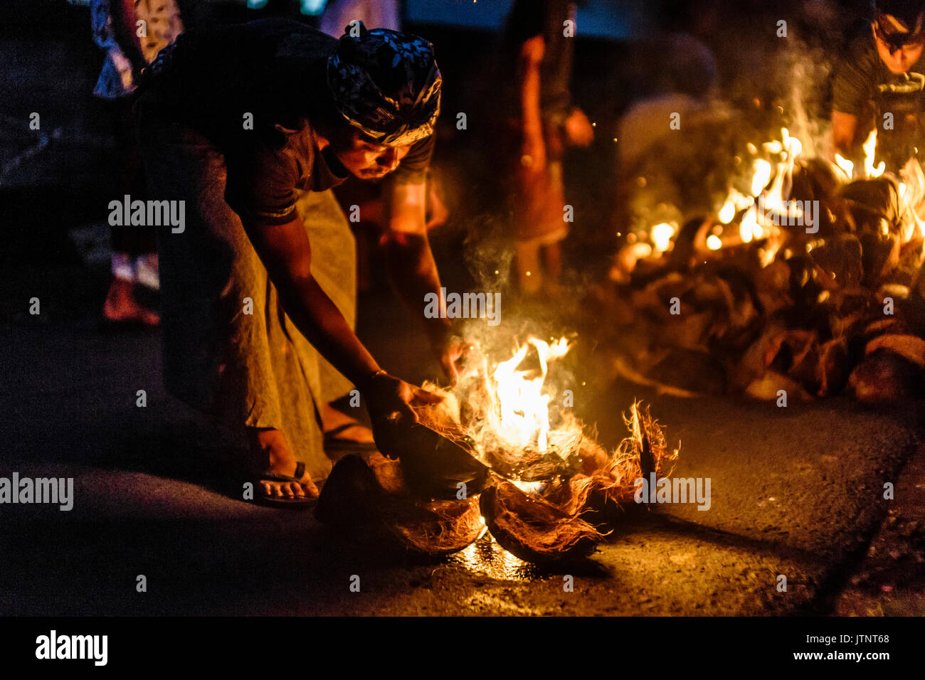 Person brennen Kokosnuss Schalen in der Nacht, Tabanan, Bali, Indonesien Stockfoto