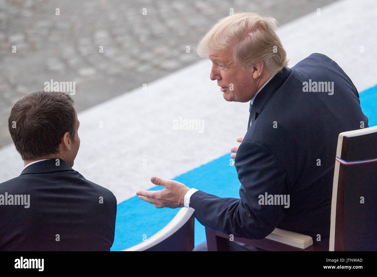 Der französische Präsident Emmanuel Längestrich Chats mit US-Präsident Donald Trump während der Bastille Tag militärische Parade entlang der Champs-Elysees Juli 14, 2017 in Paris, Frankreich. Die erste Familie in Paris wird das 100-jährige Jubiläum der Eintritt der USA in den Ersten Weltkrieg und Bastille besuchen Tag feiern zu gedenken. Stockfoto
