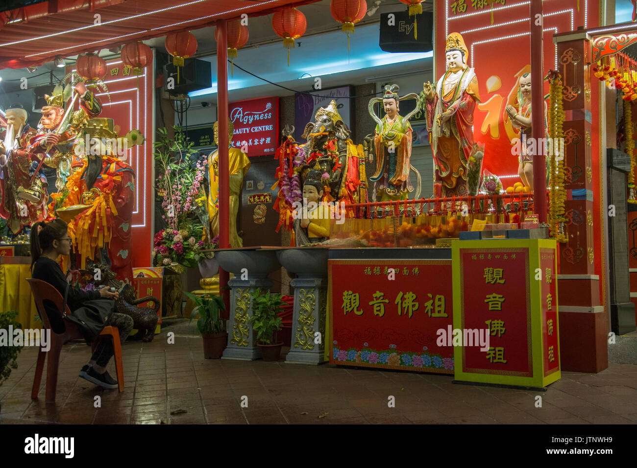 Chinesische Frau erwägt die vergoldeten Statuen des legendären und mythischen Helden auf der Waterloo Street angezeigt, Singapur Stockfoto
