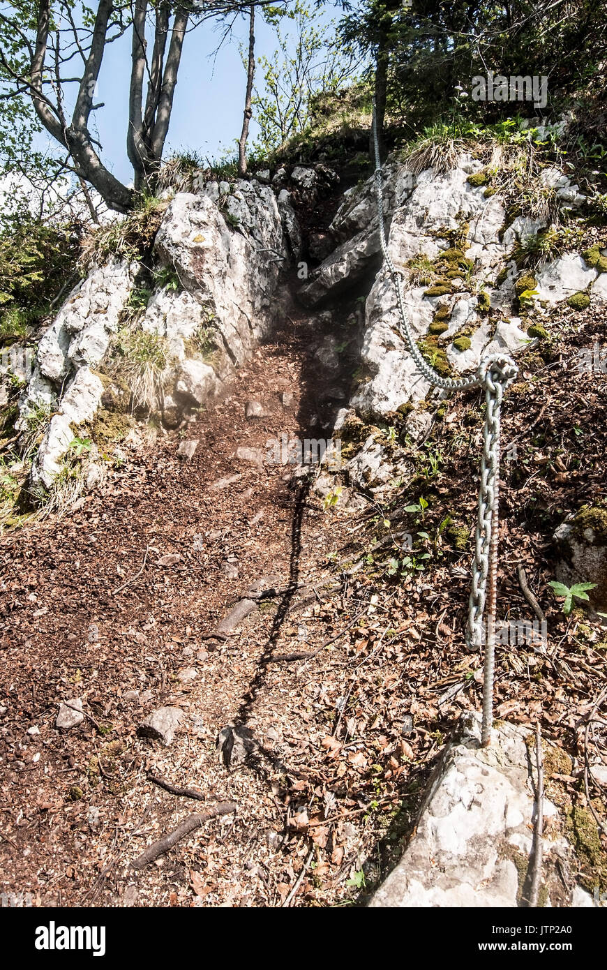 Steilen Wanderweg mit Kalksteinfelsen mit Kette mit Bäumen gesichert um geht an ostre Hügel über Svosov Dorf in Velka Fatra Gebirge in Slovaki Stockfoto