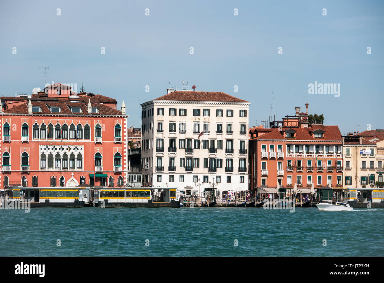 Klassische venezianische Architektur entlang der Uferpromenade günstig mit Touristen Boote und Gondeln, in Venedig, Italien Stockfoto