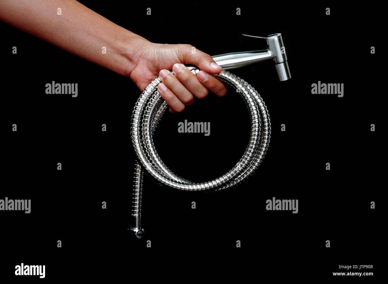 Bidet Dusche in der Hand auf schwarzem Hintergrund Stockfoto