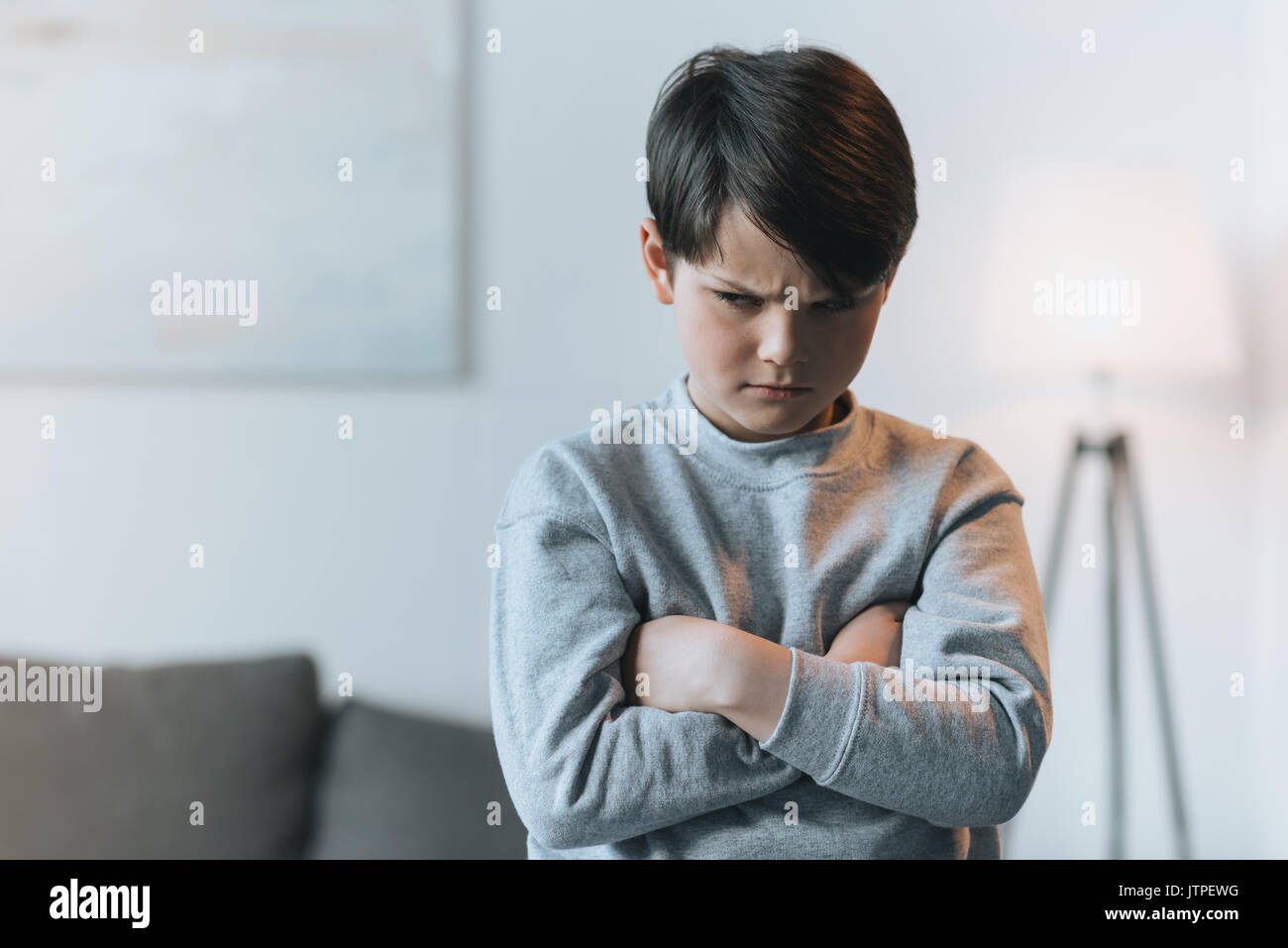 Verärgert kleines Kind Junge mit Waffen zu Hause gekreuzt Stockfoto