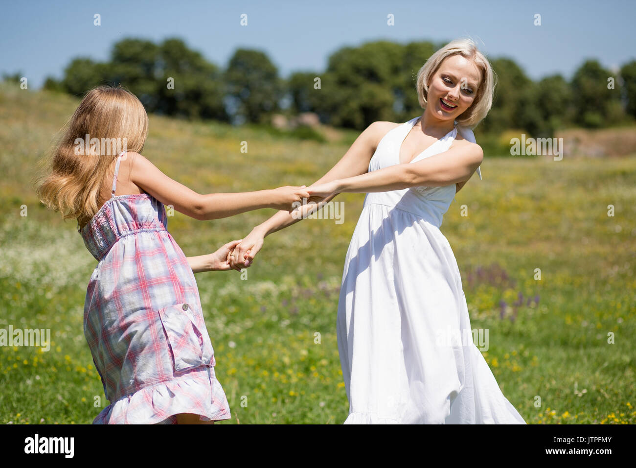 Mutter und Tochter tanzen in einer Wiese. Stockfoto