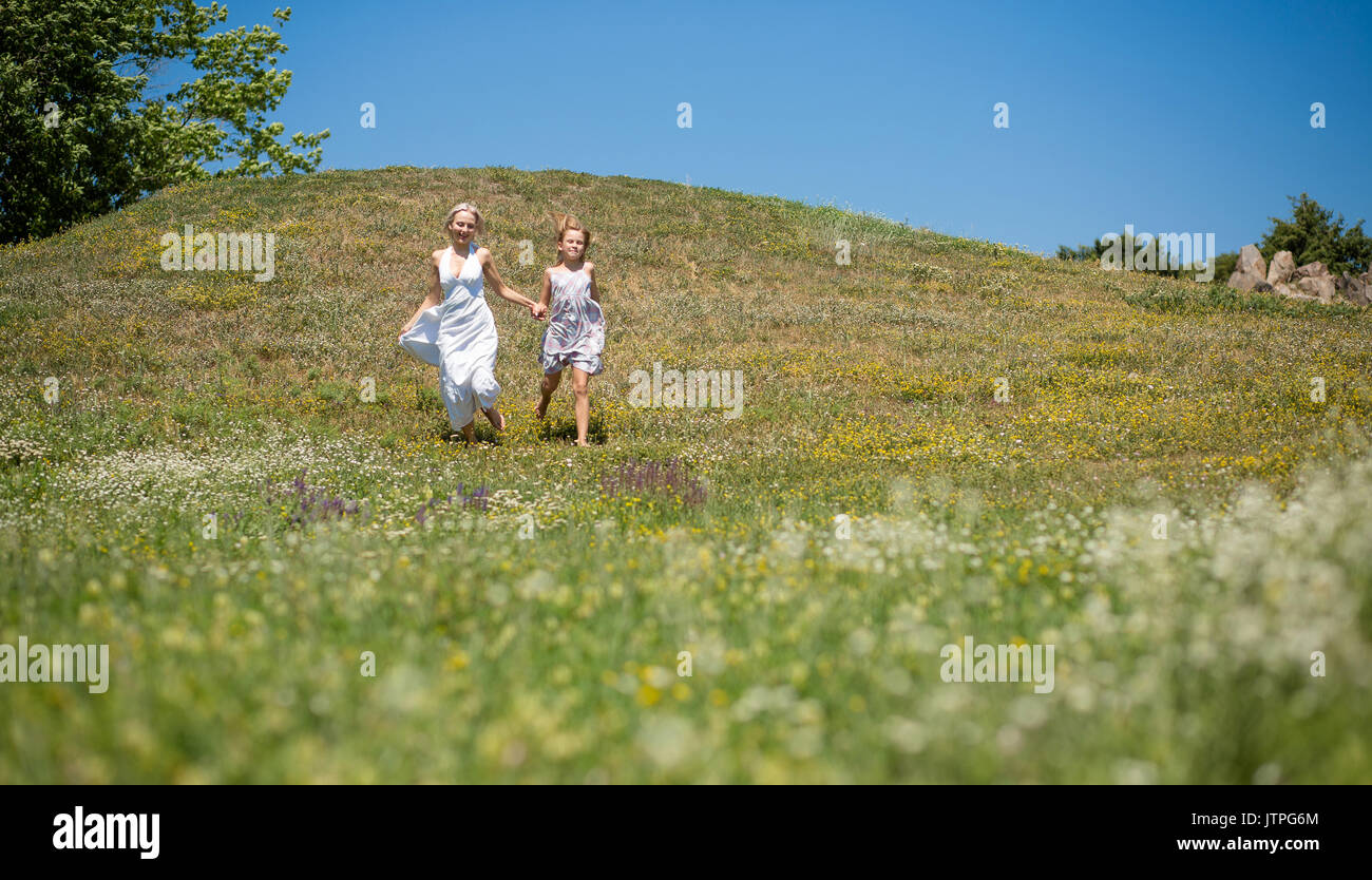 Glückliche Zeit zusammen, Mutter und Tochter läuft, halten sich an den Händen. Stockfoto