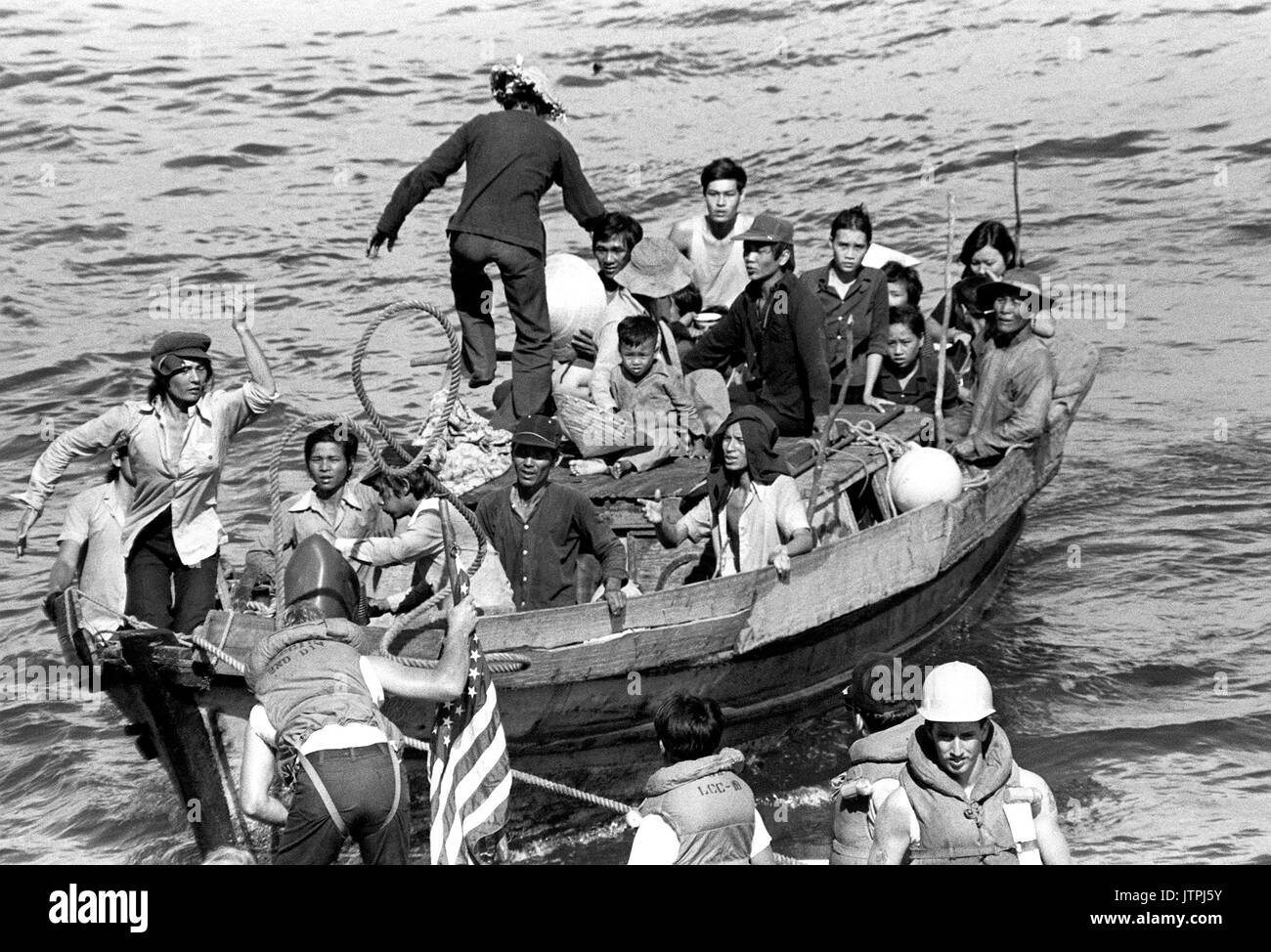 Eine Linie ist mit einem 35-Fuß-Boot von der USS BLUE RIDGE (LCC 19) Besatzungsmitglieder in einem Rettungsboot gesichert. Die amphibischen Kommando Schiff gerettet 35 vietnamesische Flüchtlinge 350 Meilen nordöstlich von Cam Ranh Bay, Vietnam, nach hatten Sie verbringen 8 Tage auf See. Sie waren nach Hongkong transportiert. Stockfoto