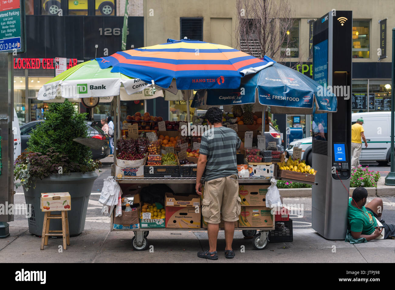Man ordnet Obst auf seinem Stand in Manhattan Stockfoto