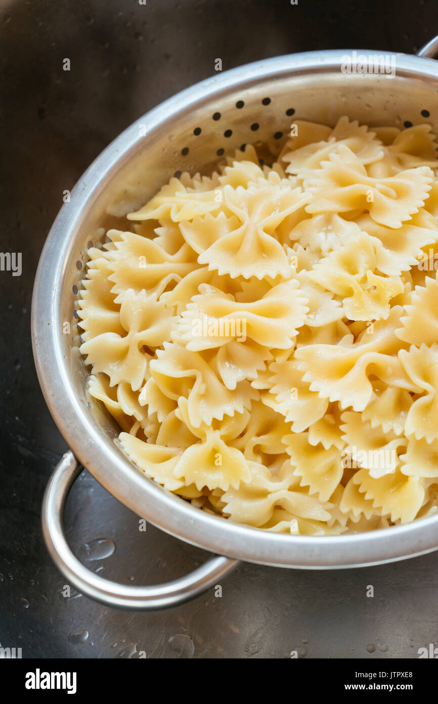 Gekochte farfalle (Bow-tie) Nudeln in einem Sieb Stockfoto