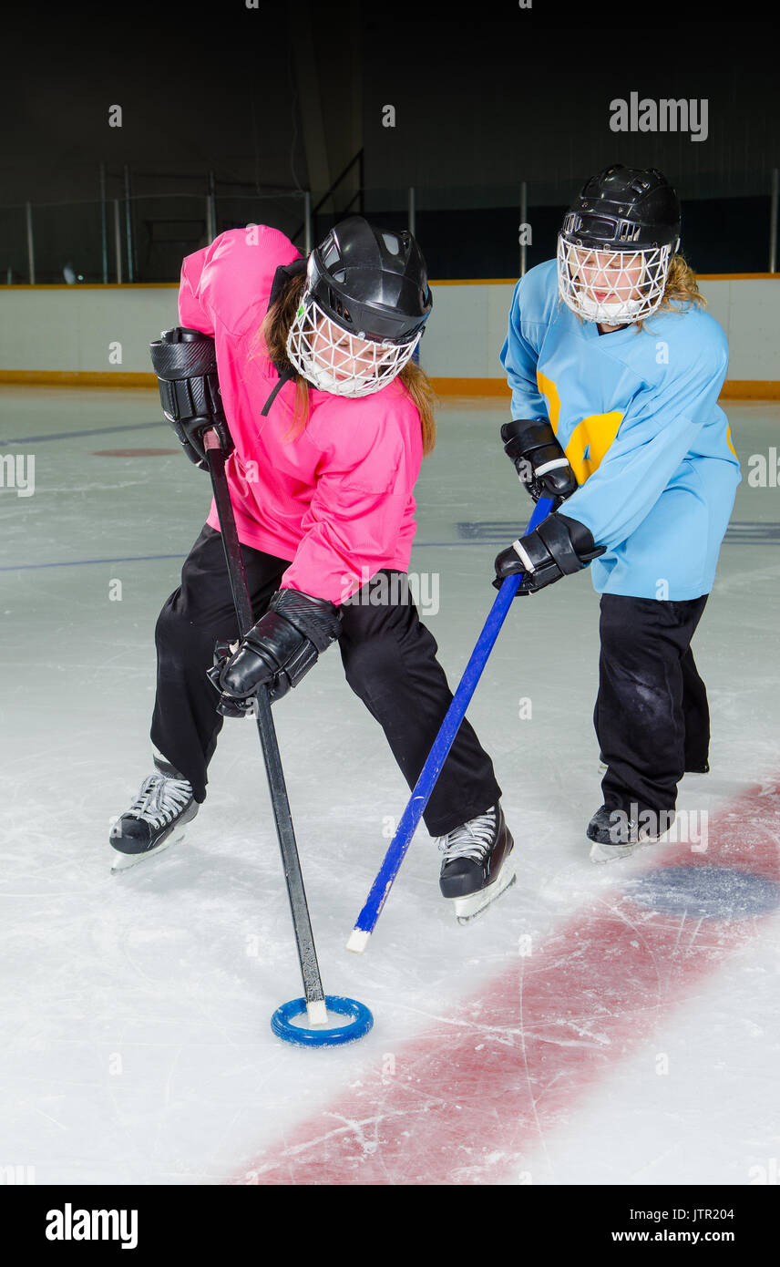 Zwei Mädchen kämpfen um den Ring, Breuberg ist eine kanadische Eis Sport spielte in einem hockey Rink oder Arena. Stockfoto