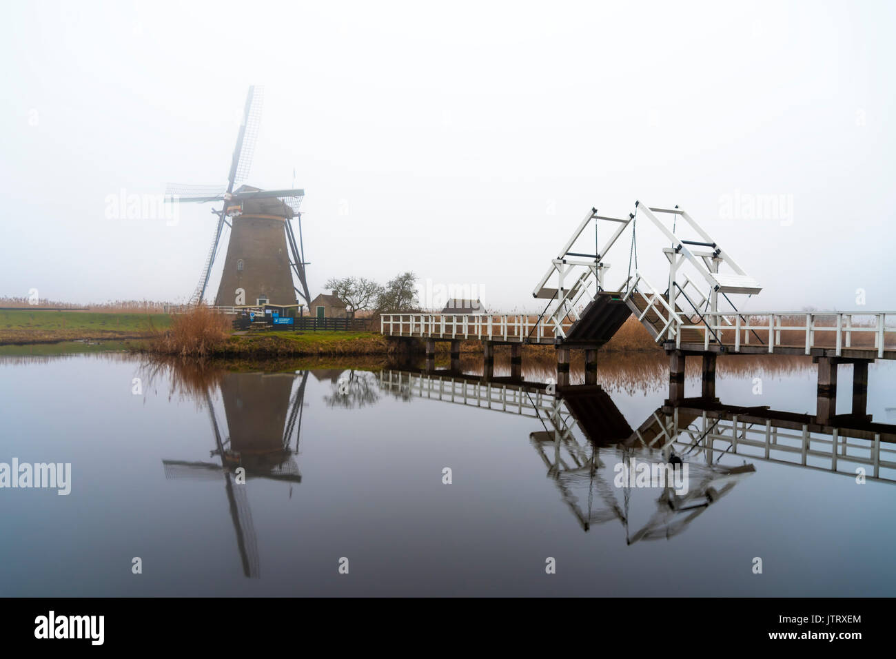 Kinderdijk Mühle Blick von der Brücke über den ruhigen Kanalwasser, Niederlande Stockfoto