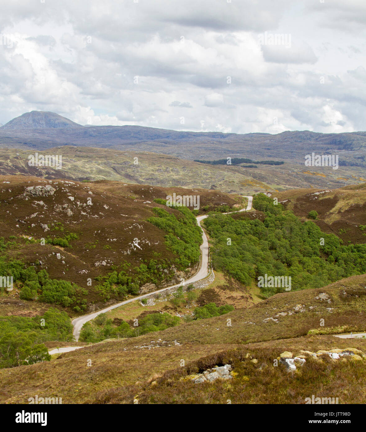 Weite Landschaft mit engen, gewundenen Straße schlängelt über schroffe Berge Berggipfel in der Nähe von Drumbeg, Schottland zu Fuß Stockfoto