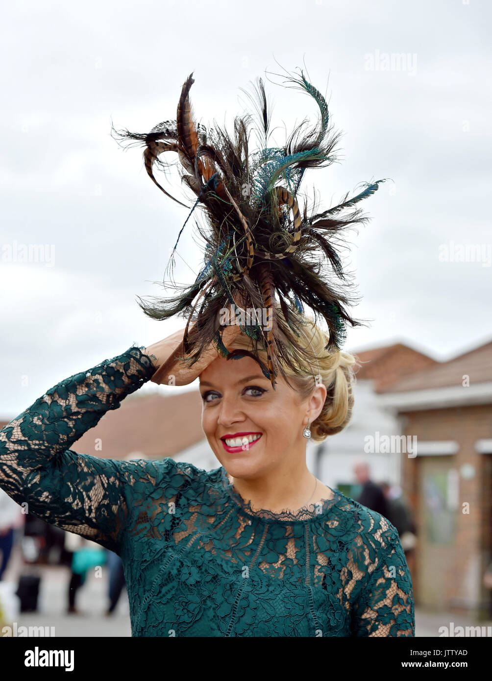 Brighton, UK. 10 Aug, 2017. Claire Sherwood mit Hut von Federn kommt für die Gelegenheit, an einem hellen, aber windigen Tag am Brighton Rennen Route Mobile Damen Tag während der drei Tage Maronthonbet Festival der Racing: Simon Dack/Alamy Leben Nachrichten gekleidet Stockfoto